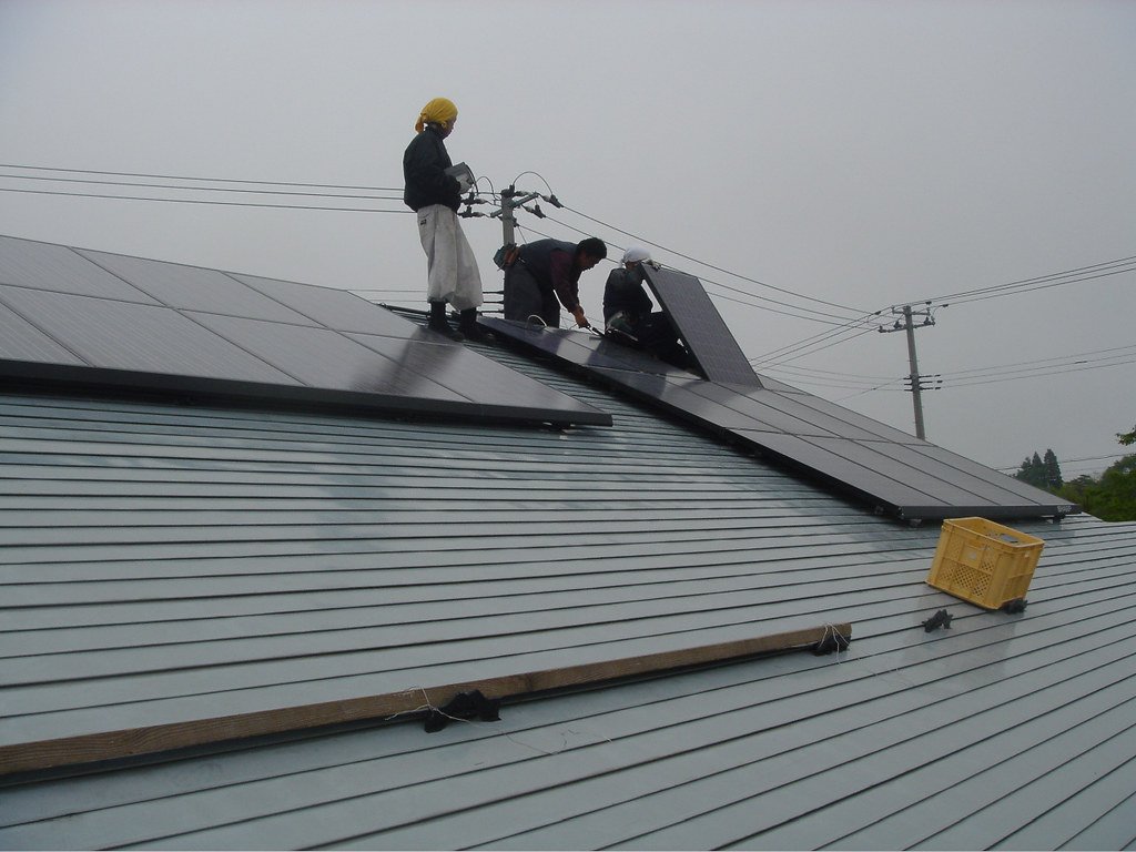 Installer fitting solar mounting rails and hardware on a roof